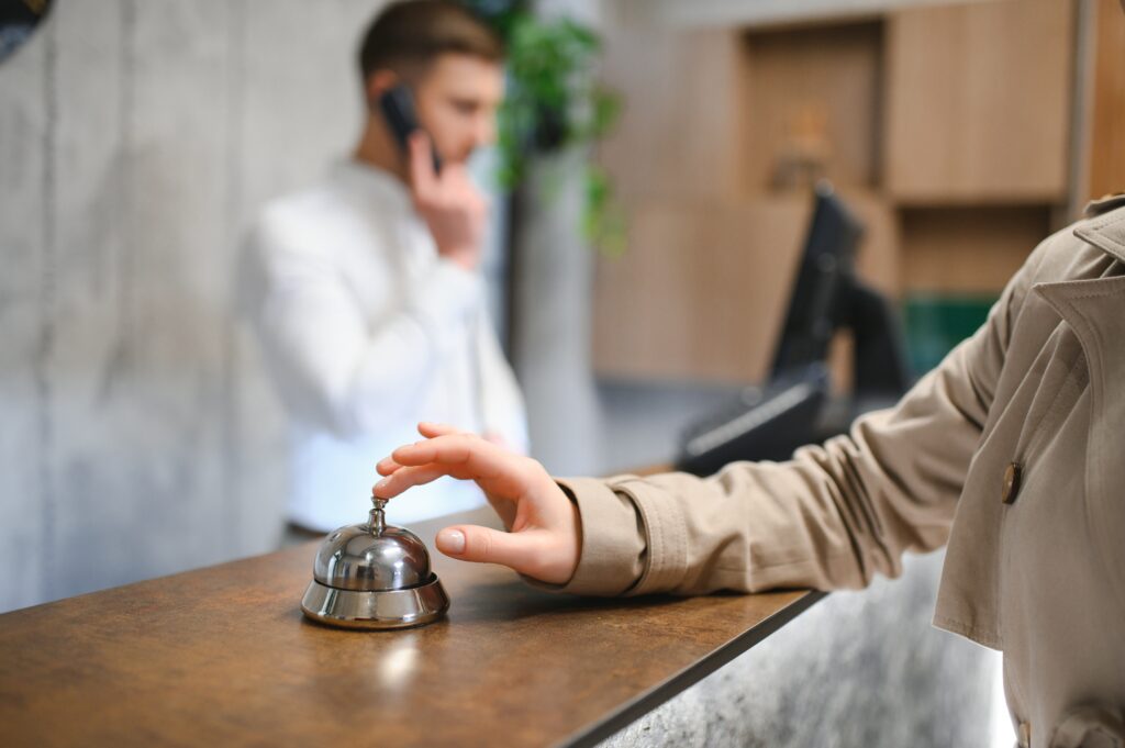 Cliente toca o sino na recepção do hotel